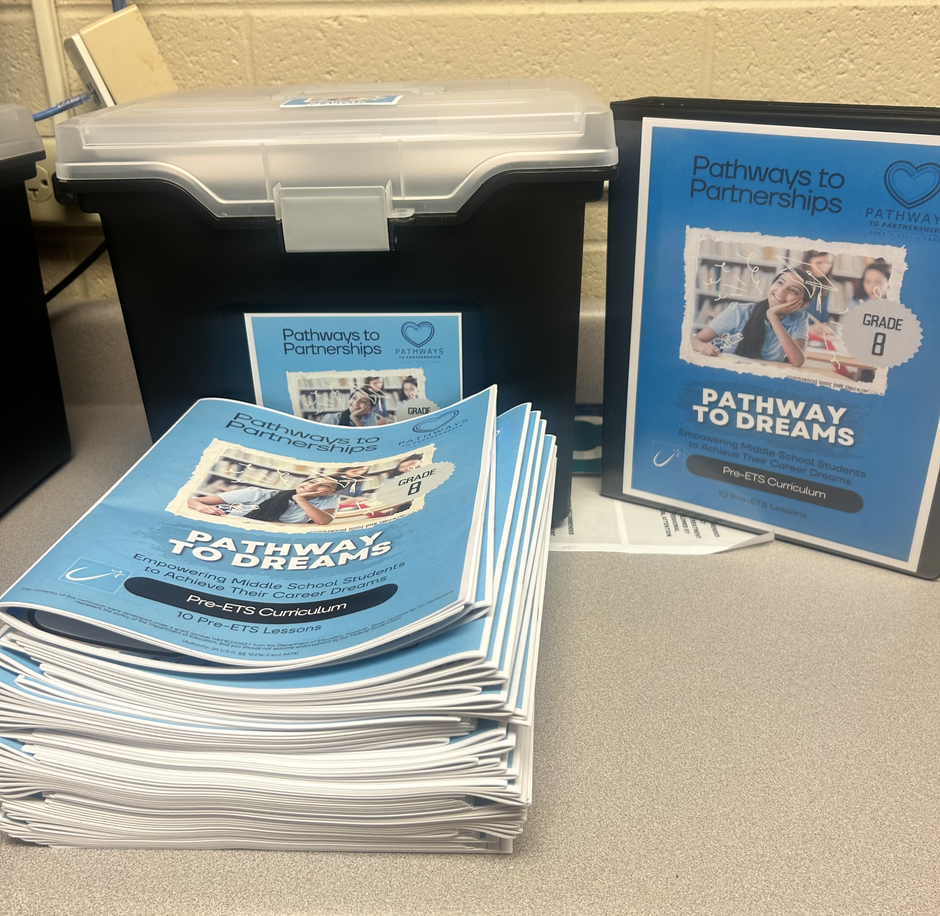 Brochures and a binder with "pathways to dreams" on the front