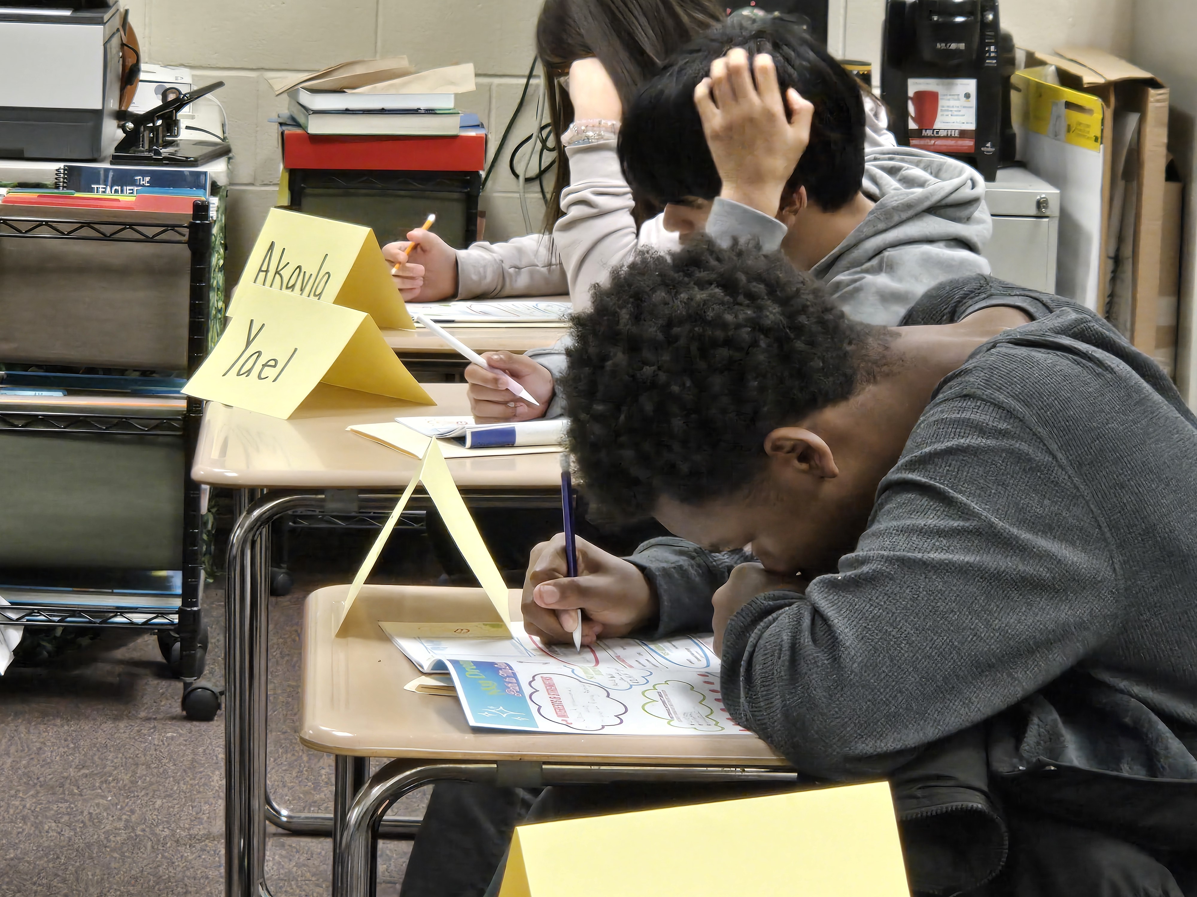 Students sitting at individual desks in class working on a document