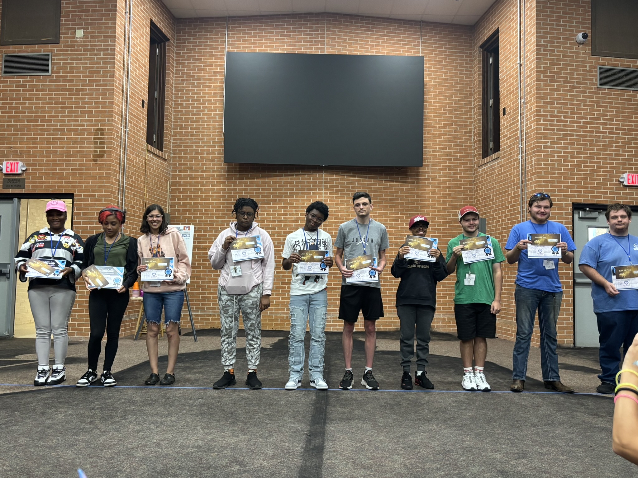 Group of students on a stage with certificates