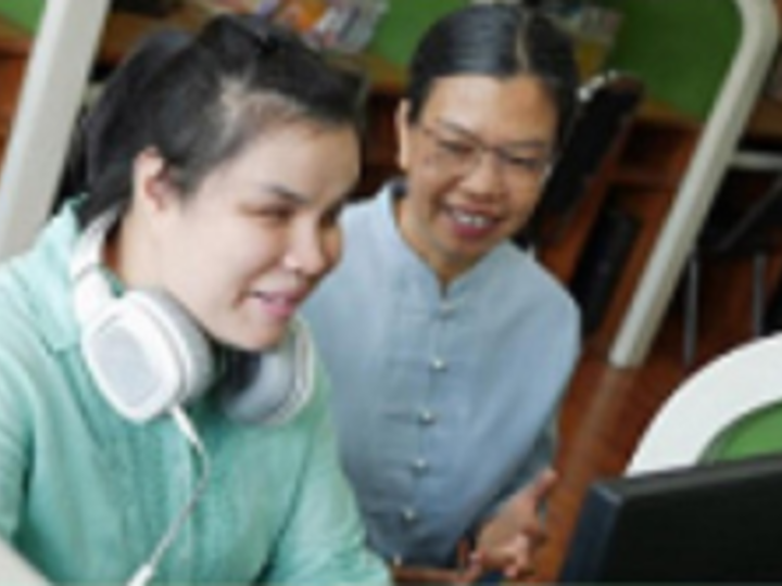Two people looking at computer.