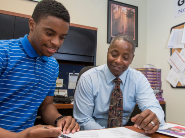 A Goodwill employee and student looking down at paperwork. 