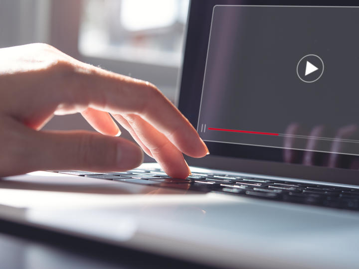 A person hand is on the laptop.