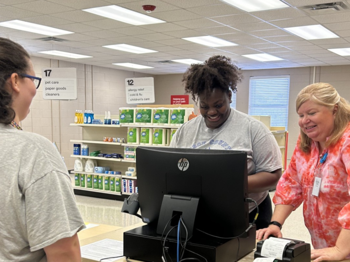 RWS student along with a teacher working on cash register.