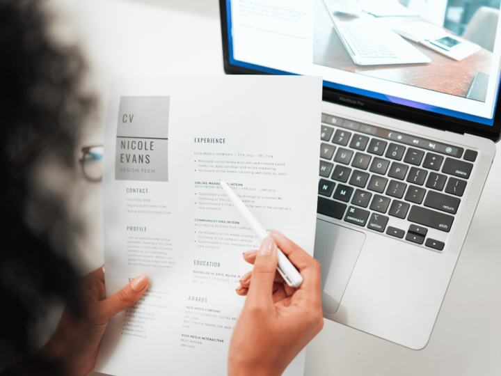 A girl working on resume with her laptop open. 