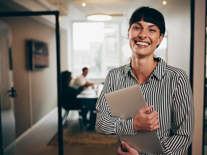 A woman holding her notepad and smiling. 
