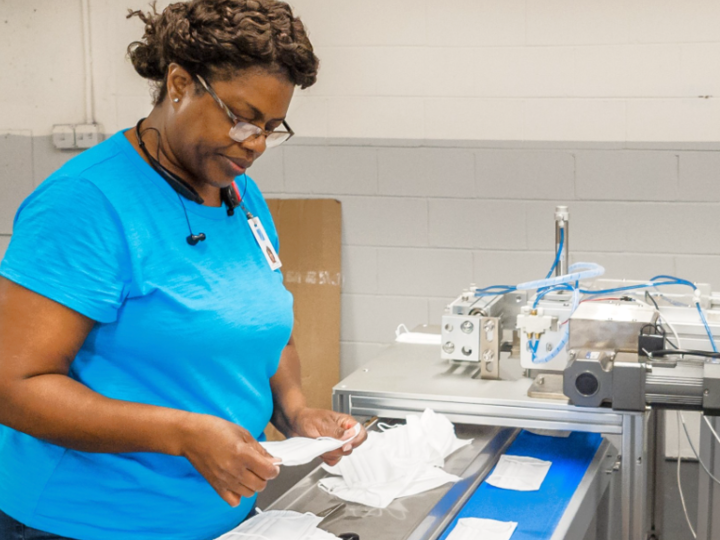 A woman working on a printer machine. 