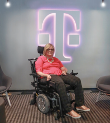 Susan Jolly seated in front of the T-Mobile logo