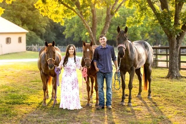 Dr. Reece and her husband holding the reins to three horses