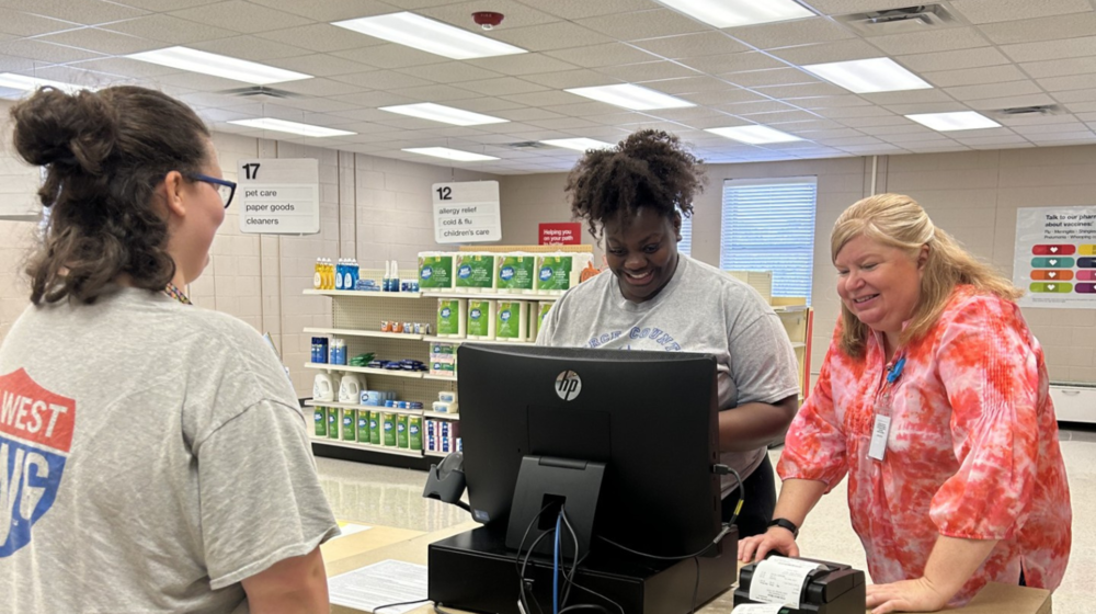 RWS student along with a teacher working on cash register.