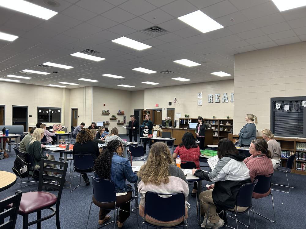 classroom of students with three facilitators