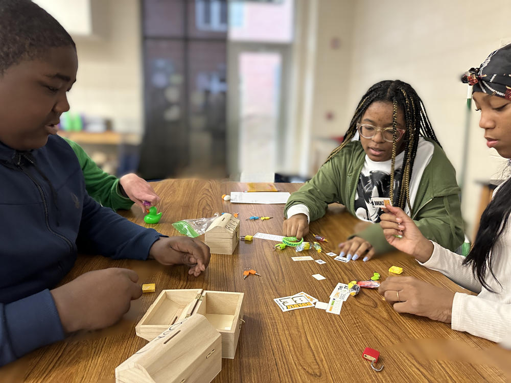 Students sitting around a table playing an educational game