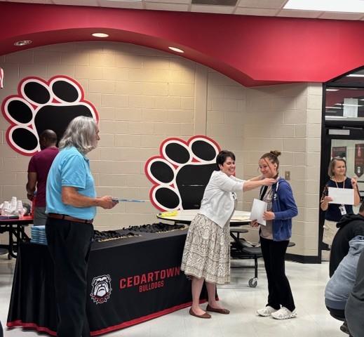 Adults and student in a cafeteria at an awards ceremony.