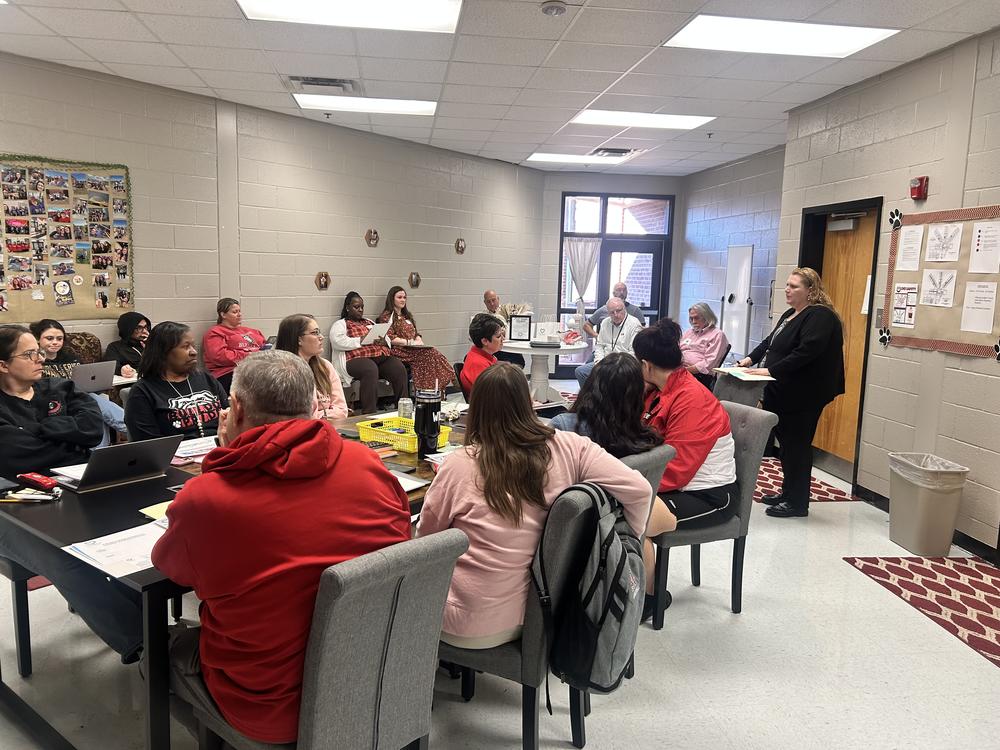 Adults in a classroom setting listing to a facilitator