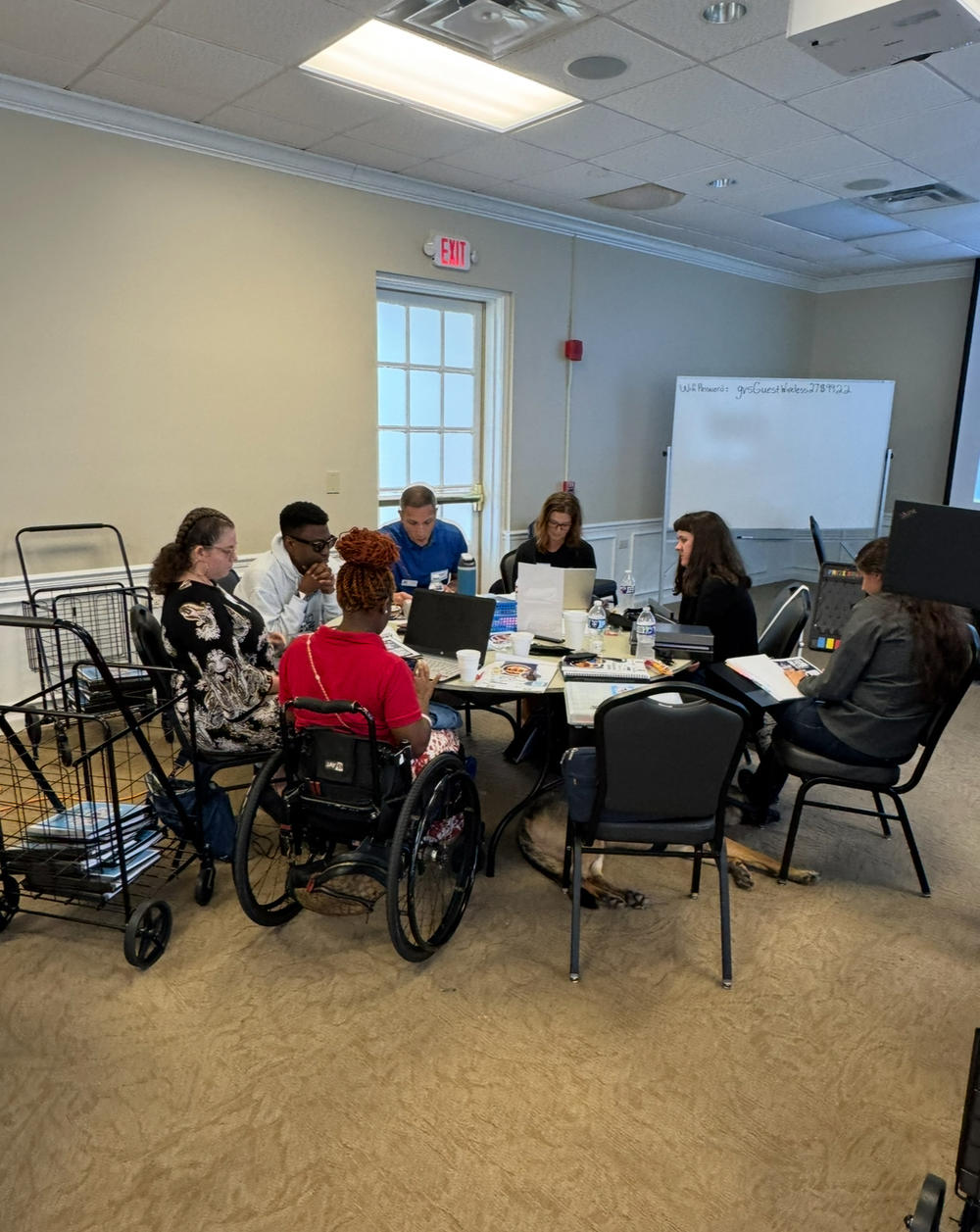 Group of people sitting in a circle around a table