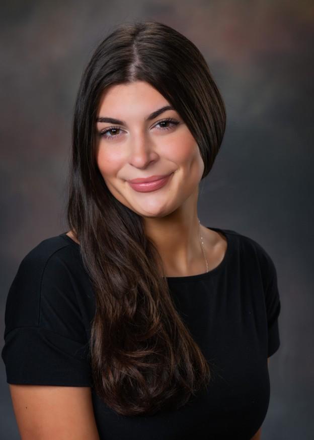 A professional headshot photo a woman smiling wearing a black shirt.