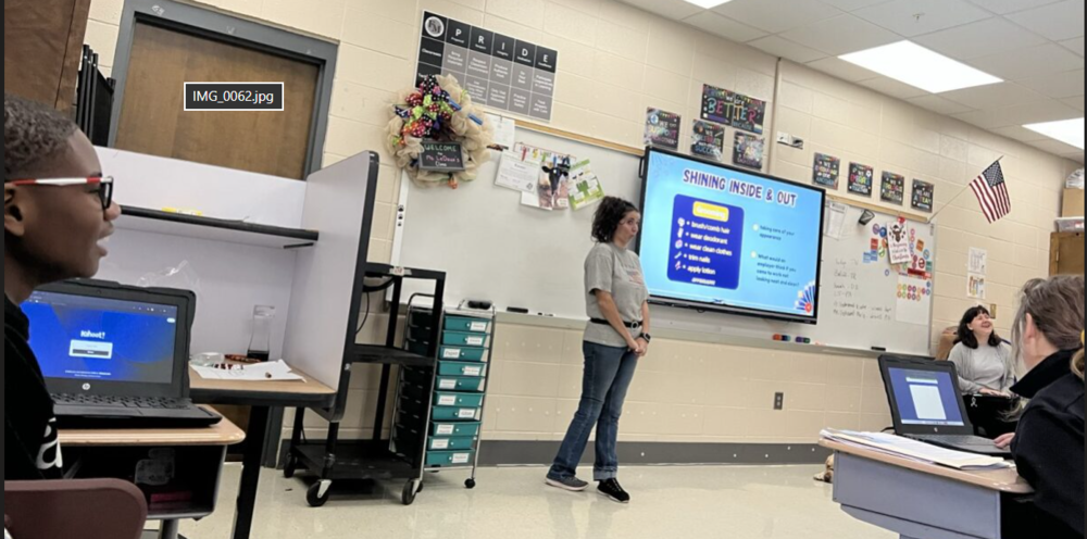 Instructor standing in the front of the classroom, in front of a white board