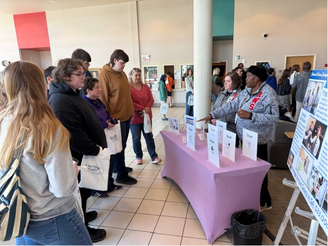 Group of people standing around table at transition fair