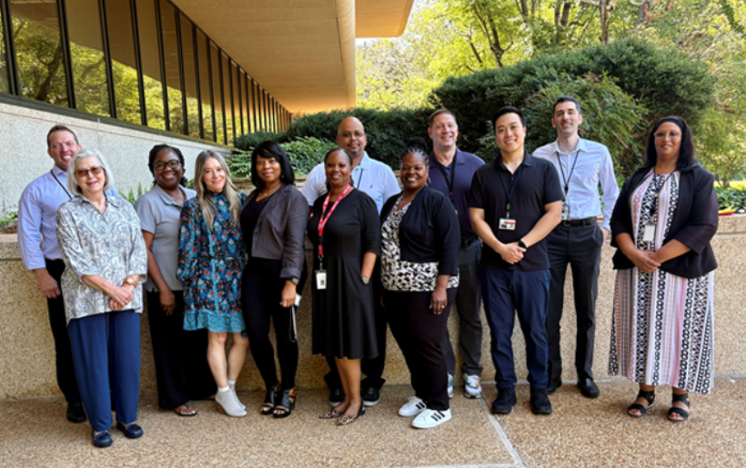 A group of professionals standing outside a building. 