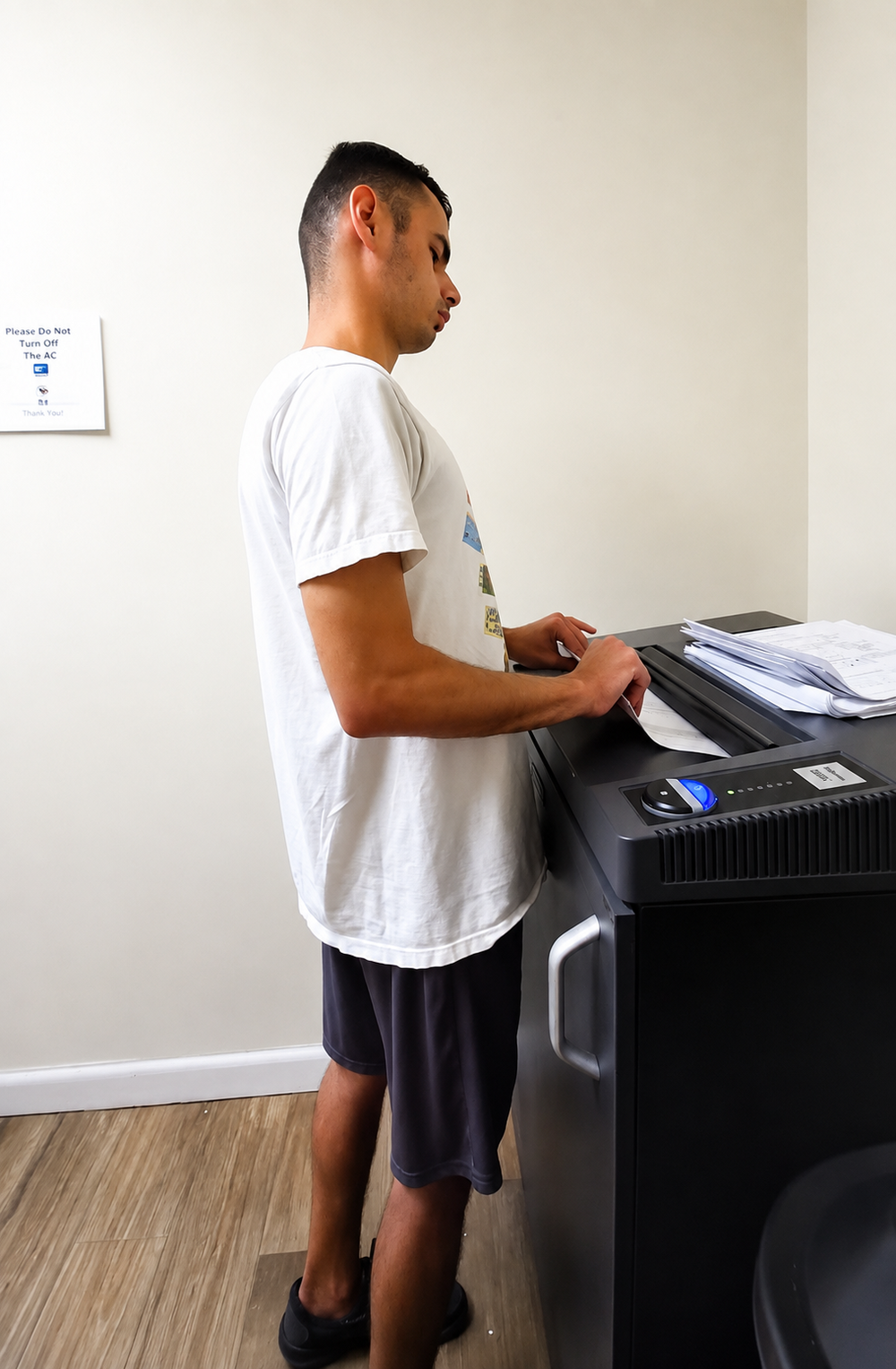 A man pulling paper from a printer. 