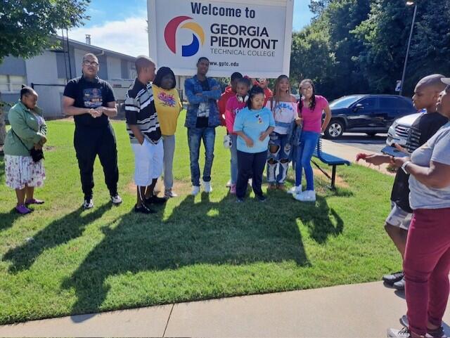 A group of students standing behind a Georgia Piedmont Tech College sign. 