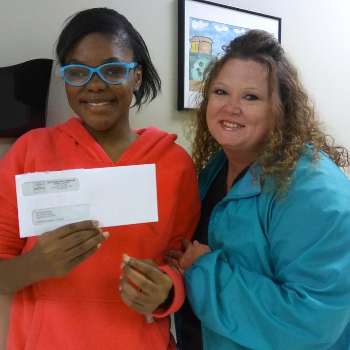 Woman showing off an envelope with another person