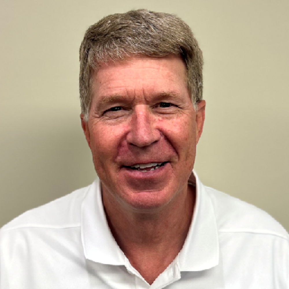 White male with graying brown hair and a white collard shirt