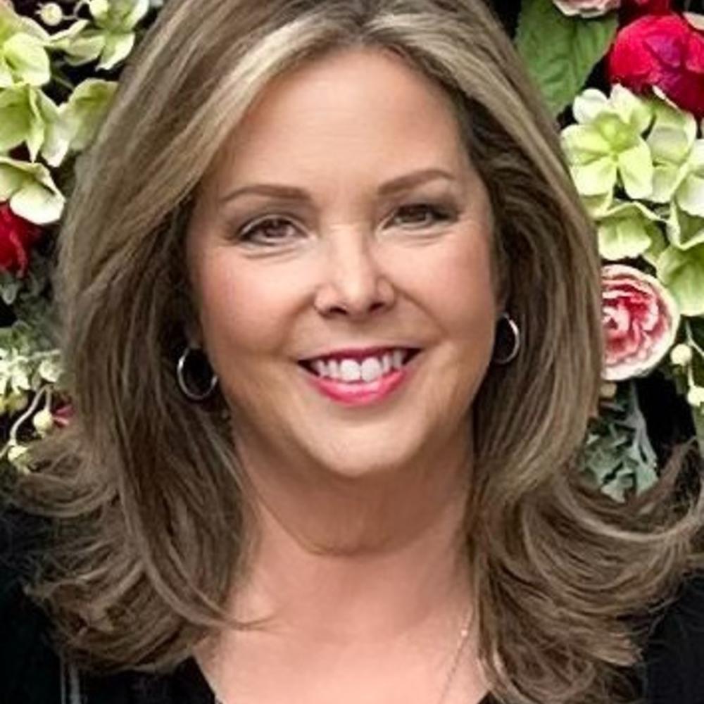 White woman with brown and blonde shoulder length hair wearing a black shirt