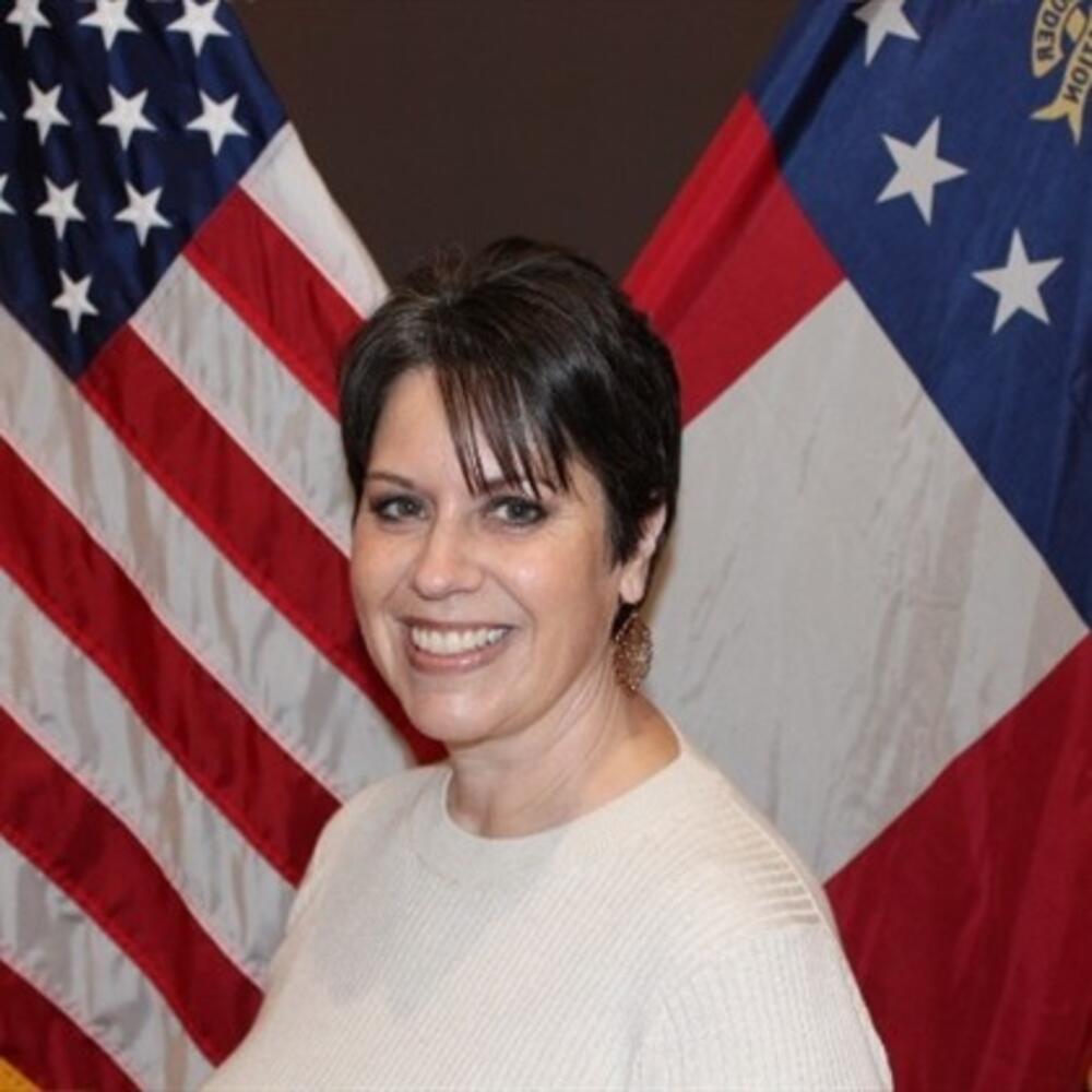 Woman with dark brown hair wearing a cream sweater