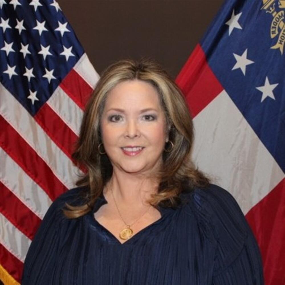 Woman with brown and blonde shoulder length hair wearing a black shirt
