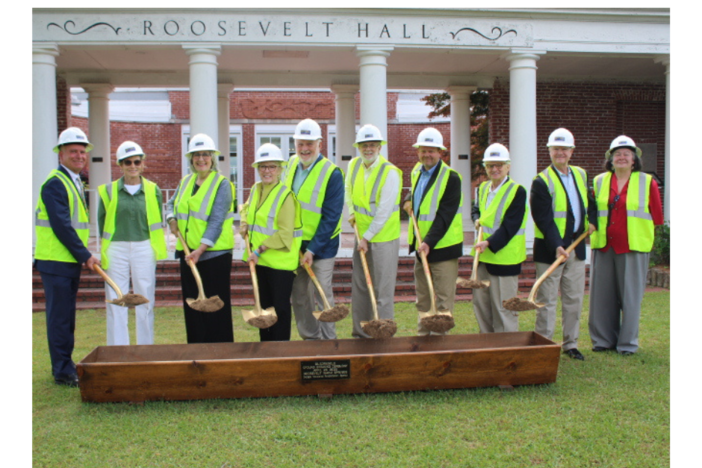 RWS staff with yellow vest and construction hats picking up dirt from their shovels.  