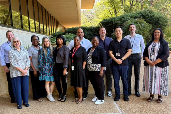 A group of professionals standing outside a building. 